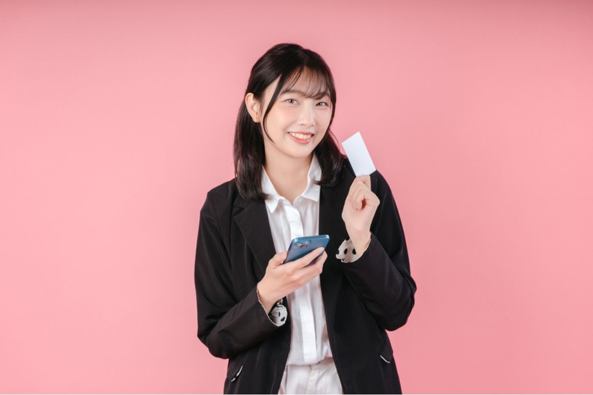 カードとスマホを持っている女性
